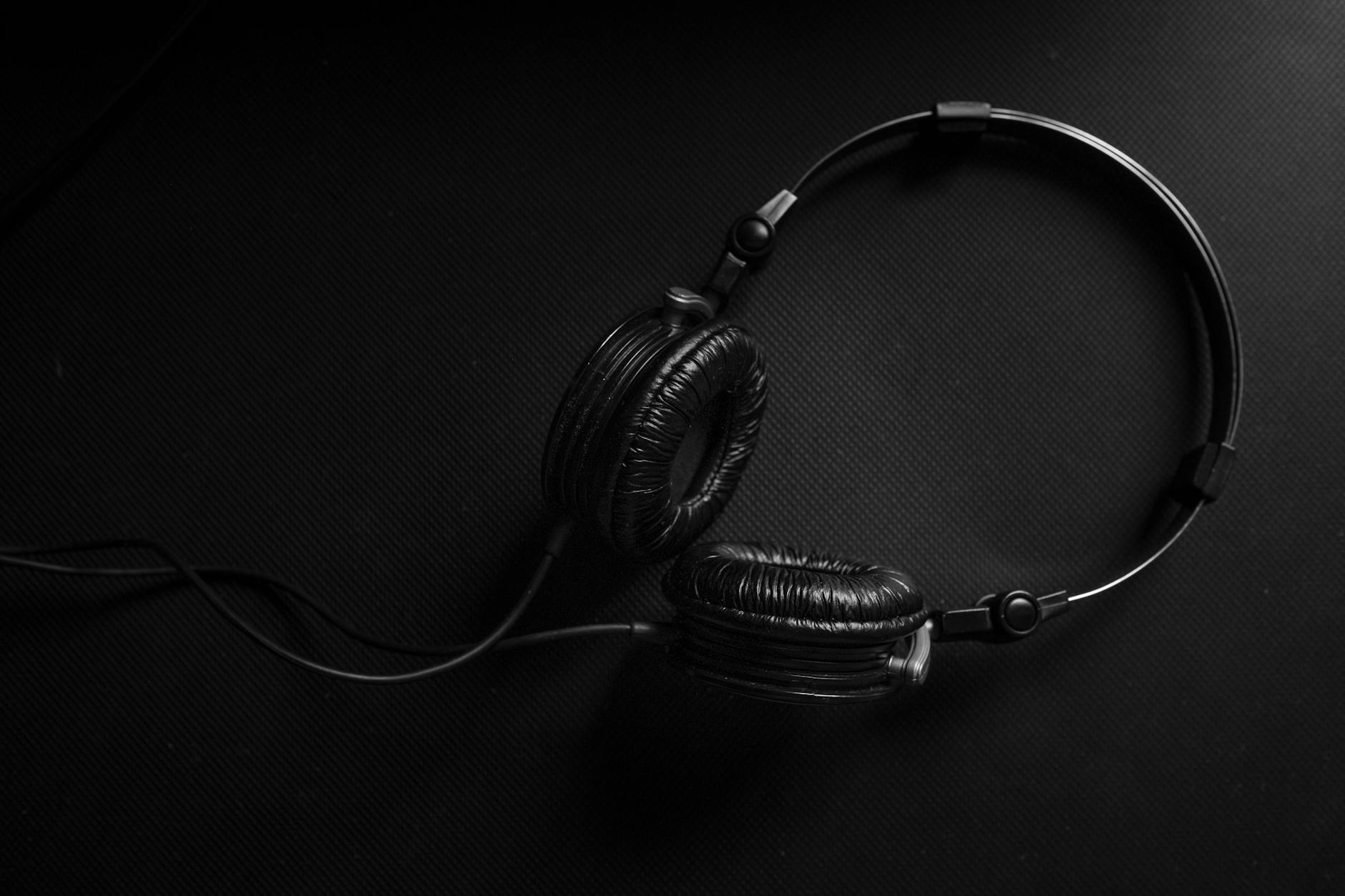 black and silver headphones on black surface
