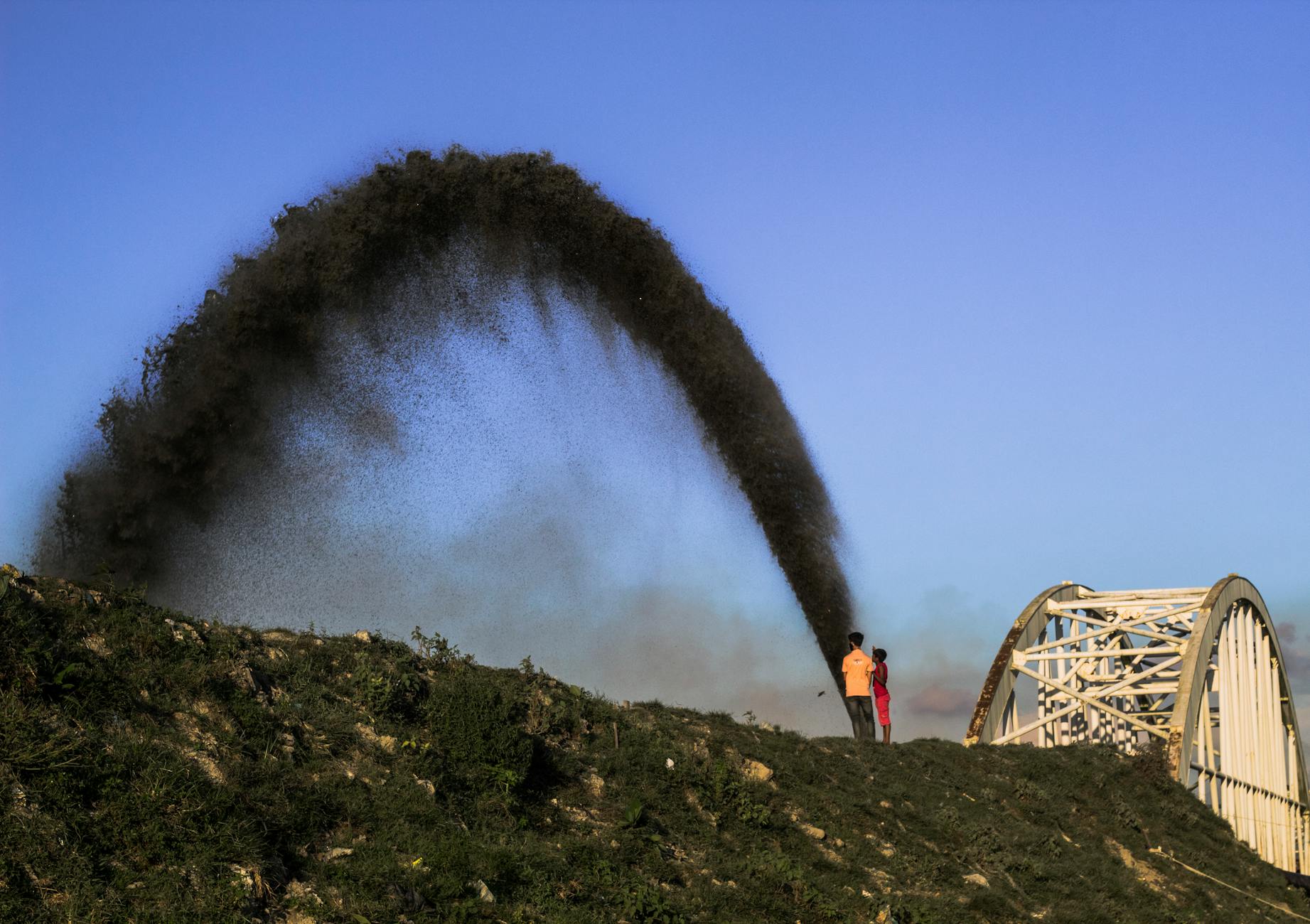 boys watching crude oil fountain