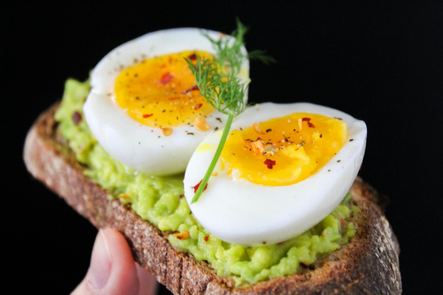 sliced egg on top of green salad with bread